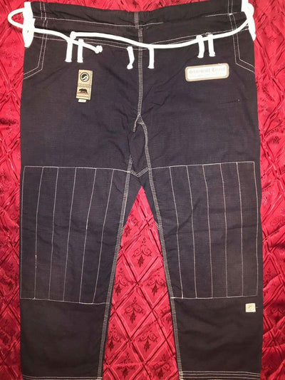 Shoyoroll Batch #8: The Yank, a navy blue Jiu-Jitsu gi featuring a lightweight 450 GSM pearl weave jacket and 12 oz ripstop cotton pants, part of the East vs. West series inspired by baseball legend 'The Great Bambino.' Includes contrast stitching, a foam collar, stretchy drawstring, ID/iPod pocket, and custom inner taping.