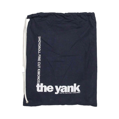 Shoyoroll Batch #8: The Yank, a navy blue Jiu-Jitsu gi featuring a lightweight 450 GSM pearl weave jacket and 12 oz ripstop cotton pants, part of the East vs. West series inspired by baseball legend 'The Great Bambino.' Includes contrast stitching, a foam collar, stretchy drawstring, ID/iPod pocket, and custom inner taping.