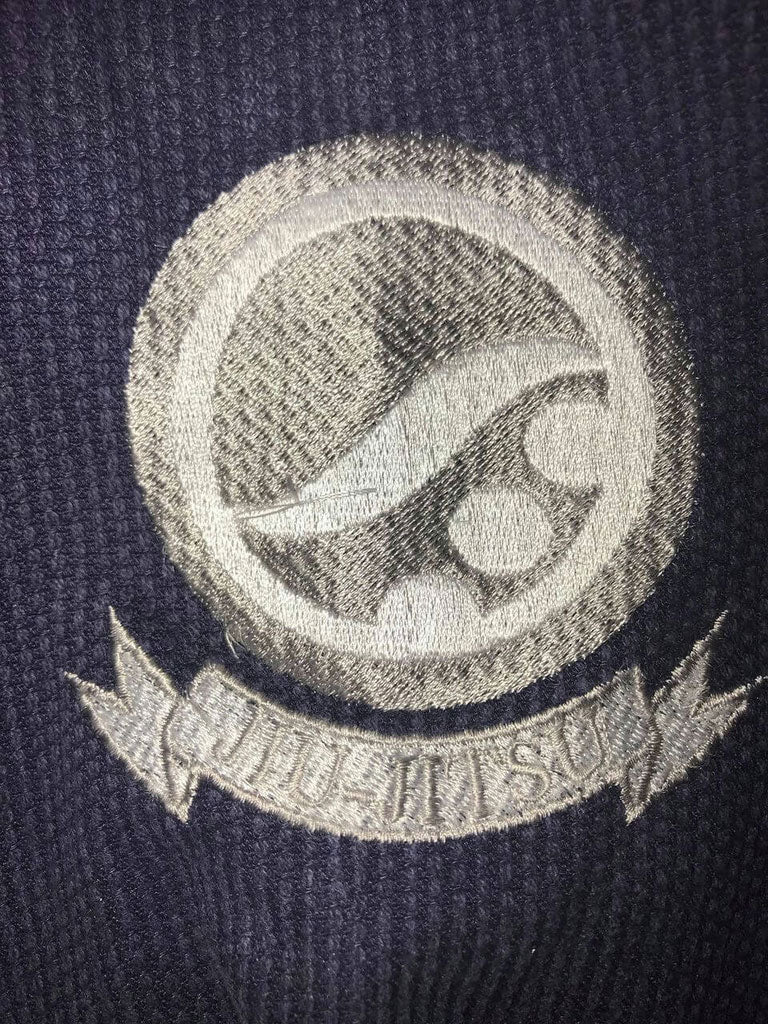Shoyoroll Batch #8: The Yank, a navy blue Jiu-Jitsu gi featuring a lightweight 450 GSM pearl weave jacket and 12 oz ripstop cotton pants, part of the East vs. West series inspired by baseball legend 'The Great Bambino.' Includes contrast stitching, a foam collar, stretchy drawstring, ID/iPod pocket, and custom inner taping.