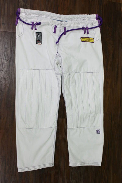 Shoyoroll Batch #8 White Mamba Gi, featuring a lightweight 450 GSM pearl weave jacket and 12 oz ripstop pants. Designed by artist John Smalls, this gi showcases a white base with purple trim. Released as part of the East vs. West Series on December 22, 2010, at 3:00 PM PST.
