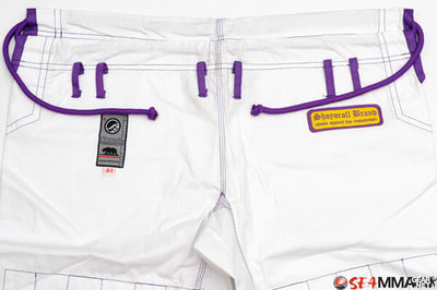 Shoyoroll Batch #8 White Mamba Gi, featuring a lightweight 450 GSM pearl weave jacket and 12 oz ripstop pants. Designed by artist John Smalls, this gi showcases a white base with purple trim. Released as part of the East vs. West Series on December 22, 2010, at 3:00 PM PST.